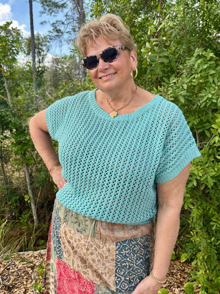 Seafoam crochet short-sleeve top with textured knit pattern and crew neckline.
