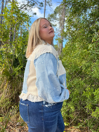 Light blue denim jacket with cream knit collar and ruffle trim, worn with distressed dark jeans.
