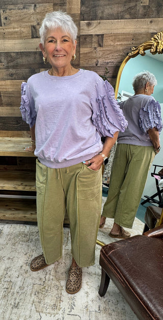 Lavender crewneck top with ruffled bubble sleeves, paired with sage green cropped pants.
