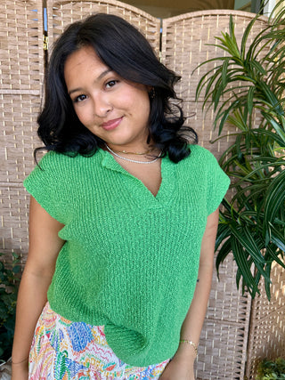 Bright green ribbed dolman sleeve sweater top with V-neckline on model.
