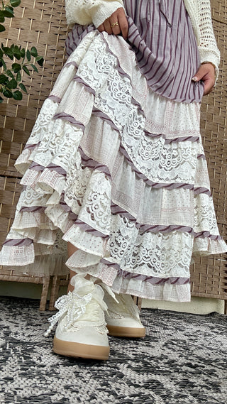Cream and dusty plum tiered ruffle skirt with white lace trim and layered details.
