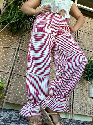 Red and white vertical striped jogger pants with ruffled cuffs and pockets, paired with white crop top.
