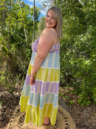Purple, blue, and yellow tiered maxi dress with leaf pattern and spaghetti straps.
