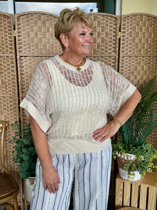 Cream textured ladderback sweater top with short sleeves and sheer knit pattern detail.
