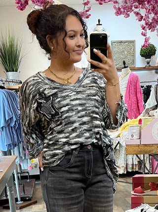 Charcoal and white zebra stripe short sleeve top with textured slub fabric, worn with black jeans.
