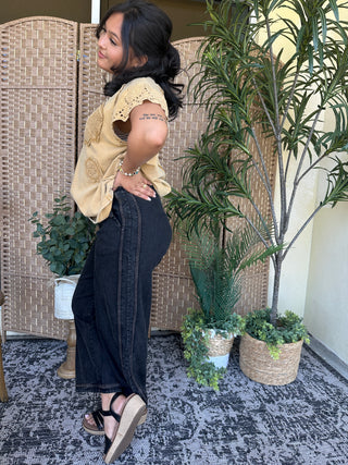 Cream crochet oversized top with eyelet details and short puffed sleeves worn with black jeans.
