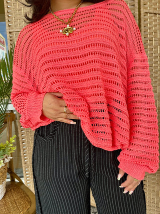 Coral crochet slouchy sweater with open knit texture and relaxed fit.
