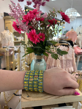 Estelle blue stretch bracelet with yellow-green square crystal stones worn on wrist.
