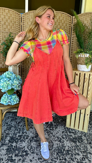 Red denim romper with colorful plaid short sleeves and A-line silhouette.
