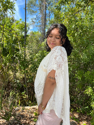 Ivory lace beachy handkerchief top with delicate floral pattern and flowing sleeves.
