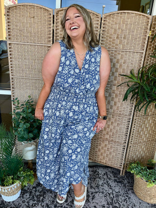 Blue and white floral sleeveless jumpsuit with V-neckline and cropped wide-leg pants.
