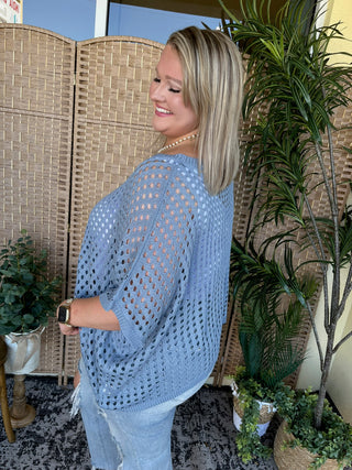 Light blue crochet dolman top with open knit pattern and three-quarter sleeves.
