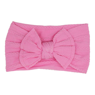 Bright pink cable knit headband with oversized bow detail.
