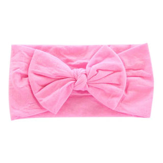 Bright pink nylon headband with centered bow and gathered fabric sides.
