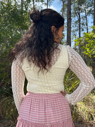Ivory mesh long-sleeve top with ditzy floral pattern, worn with pink striped skirt.
