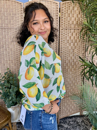 White batwing top with yellow lemon and green leaf print.
