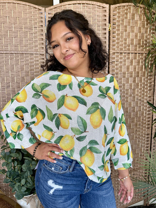 White batwing top with yellow lemon and green leaf print.
