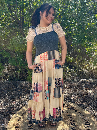 Cream patchwork midi dress with smocked denim waistband and short puff sleeves, featuring mixed fabric patches in coral, navy
