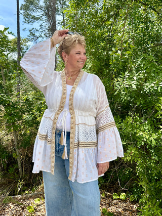 Ivory shell kimono with tan dot print, lace trim, and gold braid detailing worn open over white tank and jeans.
