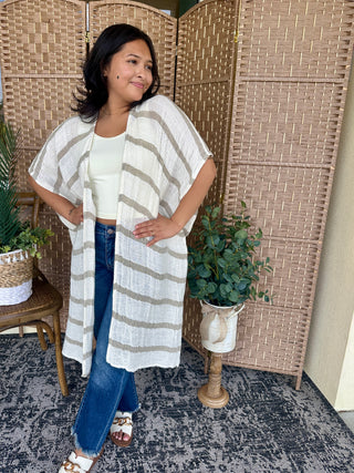 Cream and tan striped short-sleeve kimono with open front over white tank and blue jeans.
