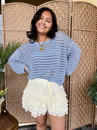 Periwinkle blue open-knit slouchy sweater with long sleeves and horizontal texture detail.
