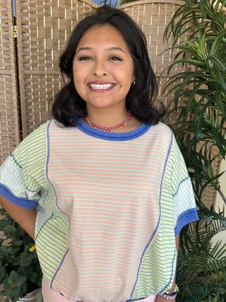 Oversized striped dolman top with blue, coral, and lime green horizontal stripes and blue ribbed trim.
