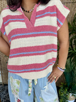Pink and cream striped knit sweater vest with blue accent stripes and V-neckline.
