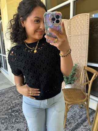 Black open weave short-sleeve sweater top with textured knit pattern and cutout details.
