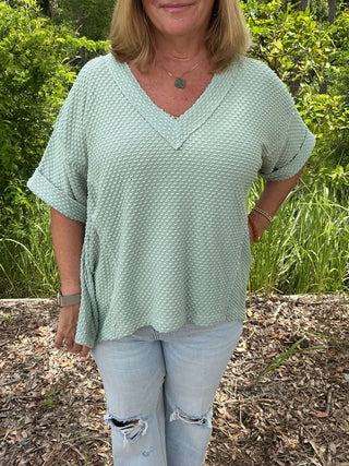 Oddi Top with Dotted Jacquard Knit, Short Sleeves & Shark Bite Hem in two colors displayed against a neutral background.