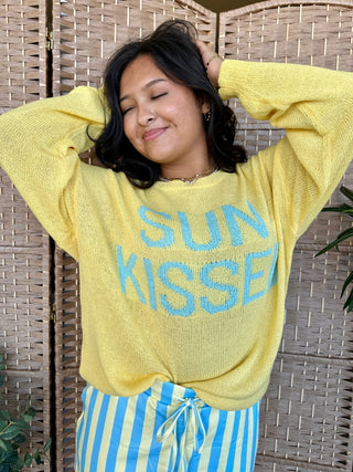 Yellow lightweight sweater with blue "Sun Kissed" text graphic.
