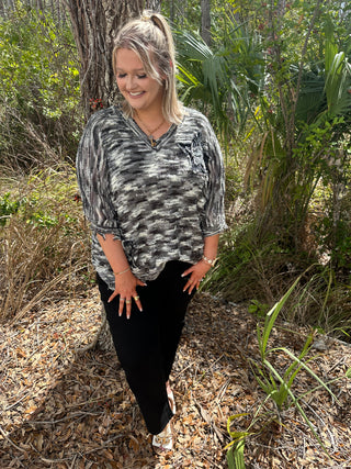 Charcoal and white tie-dye v-neck top with star patch detail and short sleeves.
