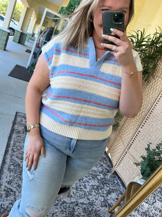 Periwinkle blue, cream, and red striped sleeveless sweater top with ribbed trim.
