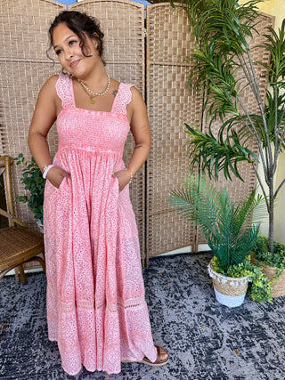 Pink eyelet sleeveless jumpsuit with smocked bodice and wide-leg silhouette.
