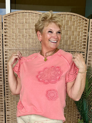Pink oversized tee with crochet doily appliqués and eyelet flutter sleeves.
