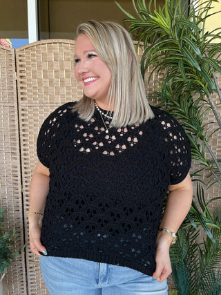 Black open weave short-sleeve sweater top with textured knit pattern and cutout details throughout.
