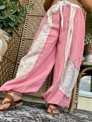 Coral pink and cream striped jogger pants with embroidered details and drawstring waist.
