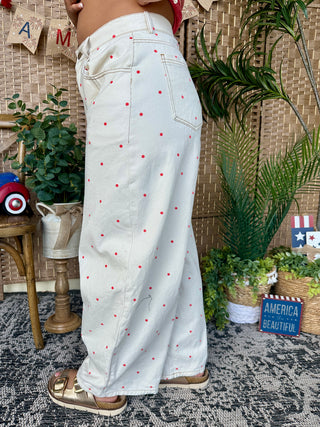 Ivory wide-leg jeans with red polka dot print, gypsy fit style.
