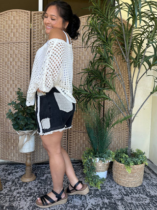 White crochet dolman top with open-weave pattern and cut-out details.

