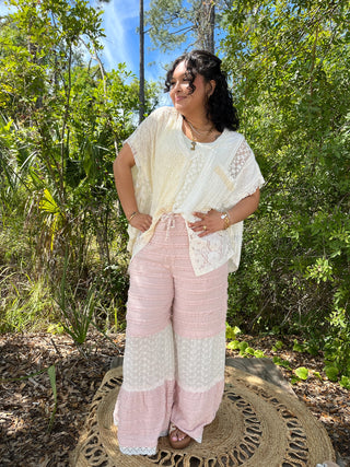 Cream lace short-sleeve blouse paired with pink and white tiered pants featuring textured stripes and lace trim.
