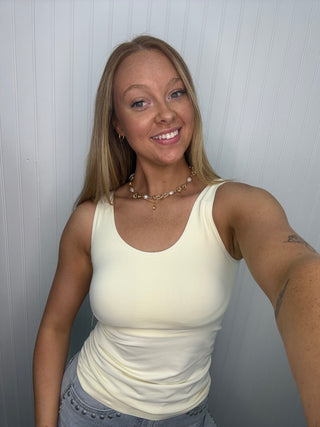 Ivory seamless tank top with built-in bra, scoop neckline, fitted silhouette.
