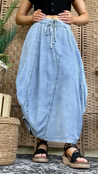 Light blue denim maxi skirt with drawstring waist and A-line silhouette.

