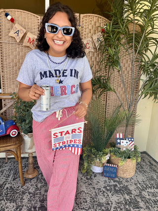 Lavender "Made In America" graphic tee with navy star and text detail.
