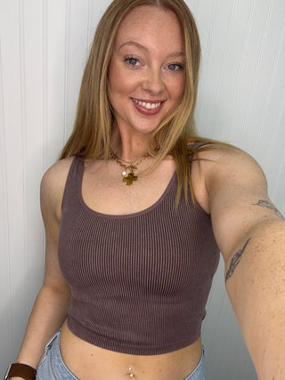 Brown ribbed seamless tank top with scoop neckline worn with light blue jeans.
