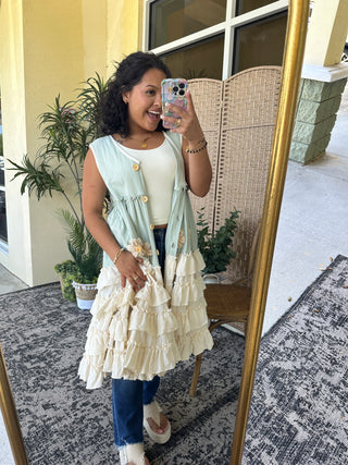 Sage green sleeveless kimono with cream ruffled tiered skirt and daisy embroidery detail.
