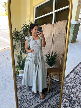 Light gray seersucker midi dress with ruffled off-shoulder sleeves and smocked waist detail.
