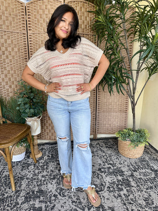 Cream crochet V-neck top with red horizontal stripes and open knit detail.
