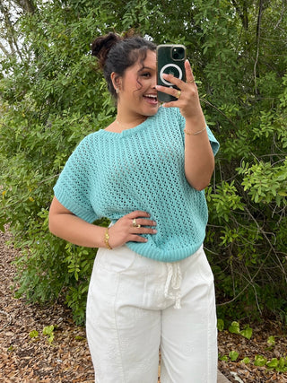 Seafoam crochet short-sleeve sweater with open knit texture and crew neckline.

