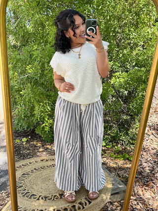 Cream textured short-sleeve top with gray and white striped wide-leg jogger pants.
