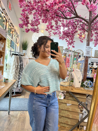 Seafoam crochet short-sleeve top with textured knit pattern worn with blue jeans.

