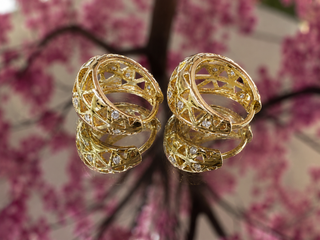 Gold filigree cutout hoop earrings with intricate lattice pattern design.
